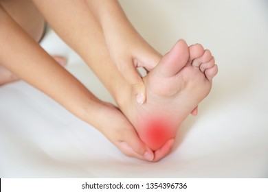 Woman, She Pain In The Heel She Is Massaging To Relieve Pain.