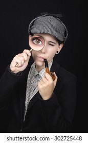 Woman as Sherlock Holmes following tracks with magnifying glass