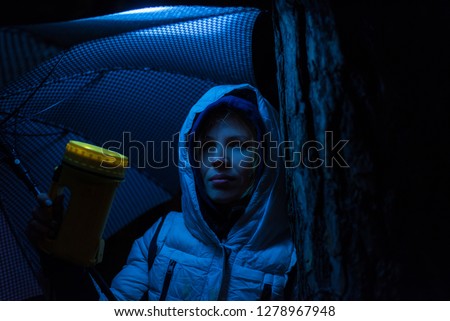 A woman shines a lantern at night.