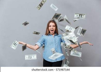 Woman In Shirt With Around Falling Money In Studio. Isolated Gray Background