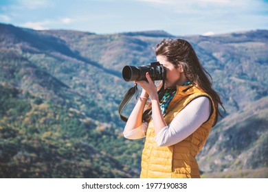 Woman Shooting with Photo Camera in the Mountain .Travel Photographer Taking Photos Outdoor  in the Nature