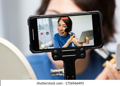 A woman shooting video with a smartphone. - Shutterstock ID 1756966493