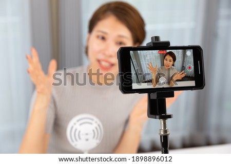 A woman shooting video with a smartphone.