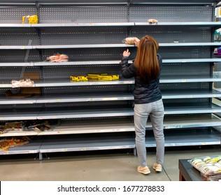 Woman Shopping Among Empty Shelves At A Supermarket During Coronavirus Pandemic 