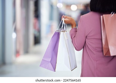 Woman, shopping bag and walking in a mall for retail therapy, sale and customer discount at a store. Hand of fashion female at commercial shop buying clothes on promotion for commerce on travel