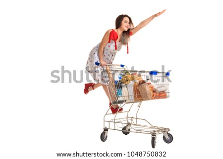 Woman with shopping cart full with products isolated over white background