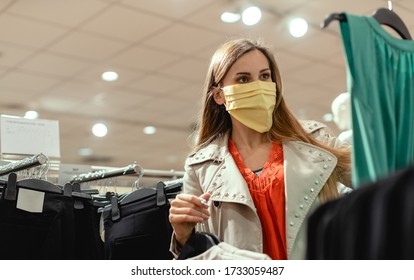 Woman Shopping In Fashion Store Wearing Face Mask Looking At Some Clothes