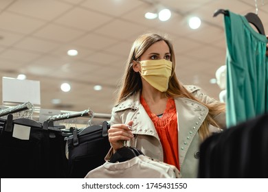 Woman Shopping In Fashion Store Wearing Face Mask Looking At Some Clothes