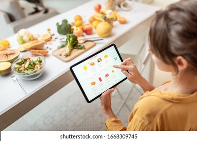 Woman Shopping Food Online Using A Digital Tablet At The Kitchen. Concept Of Buying Online Using Mobile Devices