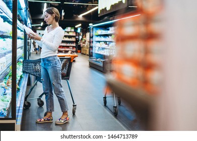 Woman Shopping At The Grocery Store, By The Refrigerator