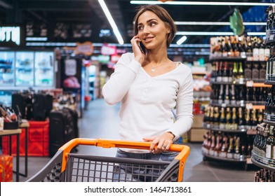 Woman Shopping At The Grocery Store And Talking On Phone