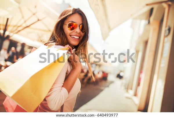 Woman in\
shopping. Happy woman with shopping bags enjoying in shopping.\
Consumerism, shopping, lifestyle\
concept