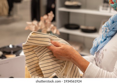 Woman Shopping In A Home Improvement Store, Holds A Placemat In Her Hand