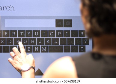 Woman At Shopping Mall Looking For Directions On A Digital Directory Board