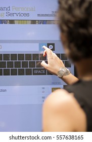 Woman At Shopping Mall Looking For Directions On A Digital Directory Board