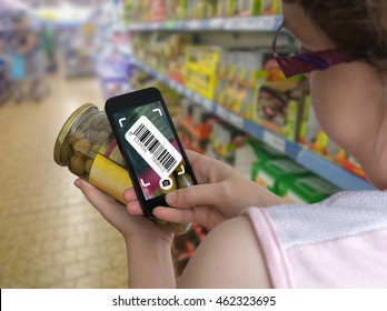 Woman Is Shopping In Supermarket And Scanning Barcode With Smartphone In Grocery Store To Get Online Info About Product.