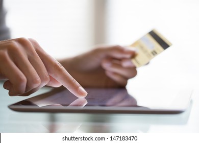Woman shopping using tablet pc and credit card .indoor.close-up