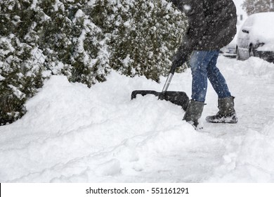 Woman Shoveling Snow On Pavement