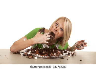 A Woman Shoving Her Face With Cake .