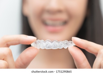 Frauen zeigen kieferorthopädische Silikontrainer. Mobile Kieferorthopädie zur zahnärztlichen Korrektur. Zahnweißsysteme.