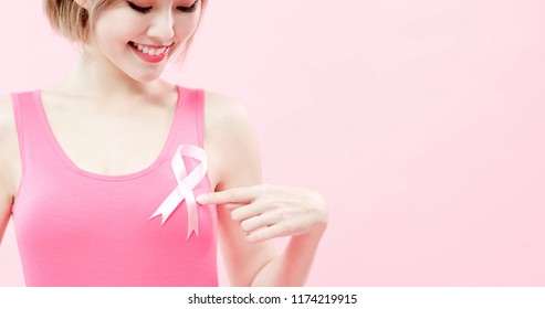 woman show pink ribbon with prevention breast cancer concept - Shutterstock ID 1174219915