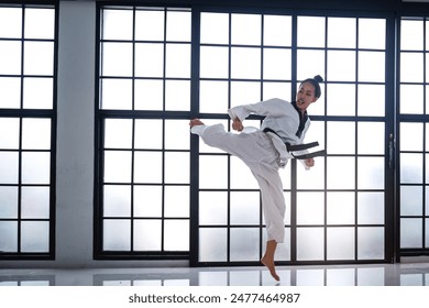 Woman show a strong kick for Taekwondo battle, Martial arts training in training studio - Powered by Shutterstock