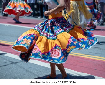 Woman showing dance moves wearing a Mexican fiesta dress at an outdoor march