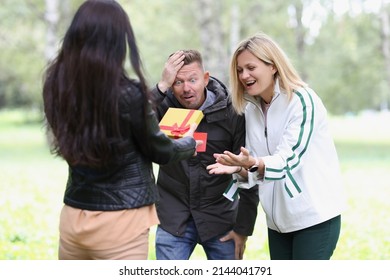 Woman Showing Gift Box To Shocked Friends. Emotions Of Joy And Enthusiasm Concept