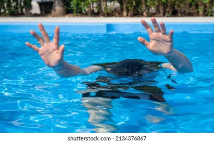 Woman showing her hands while drowing in swimming pool. Drowning is the process of experiencing respiratory impairment from submersion or immersion in liquid.