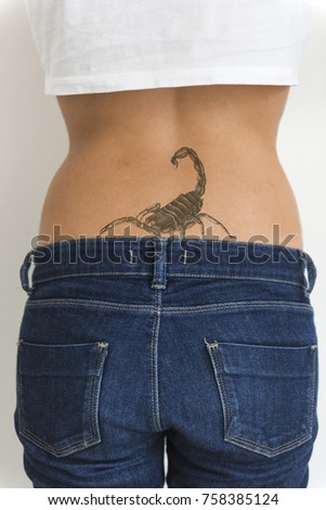 A woman is showing her tattoo on her hips