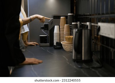 Woman showing how to make coffee in the office - Powered by Shutterstock