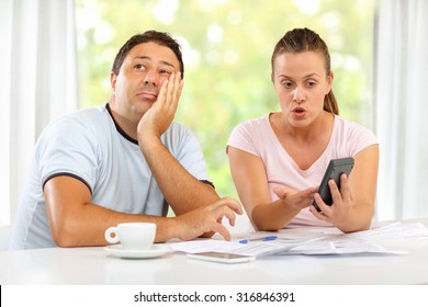 Woman Showing To The Man Figures On Calculator But He Is Not Interested