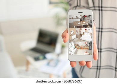 Woman showing mobile phone with images of cctv cameras installed in apartment on screen, closeup