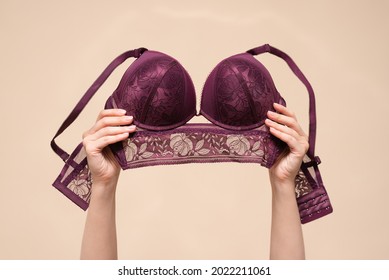 Woman is showing a new bra in the hand above her head. Choosing a new bra concept.