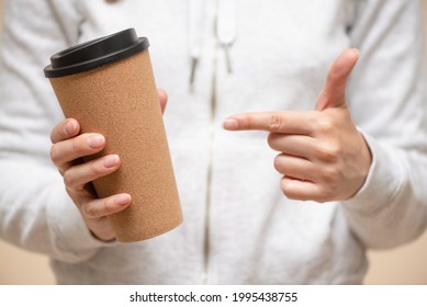 Woman Is Showing On The Mug Of Coffee By Her Index Finger Close Up.