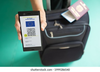 Woman Showing On Smartphone EU Digital Covid Certificate With Quad Code. With Passport, Boarding Pass And Baggage.