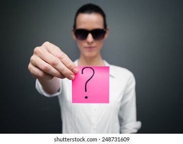 Woman showing paper with question mark on it