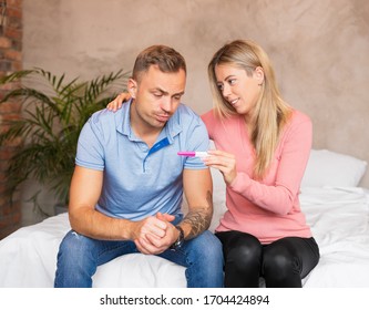 Woman Showing Pregnancy Test To A Worried Man