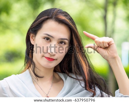 Woman showing small amount size gesture with hand fingers.  Human emotion facial expression feelings symbol.