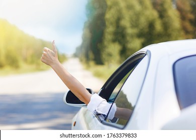 Woman Showing Thumbs Up/making Like / Ok Sign With Hand From Car Window With Sunset Sky, Relaxing, Enjoying Road Trip And Feeling The Air And Freedom. Toward Adventure, Vacation