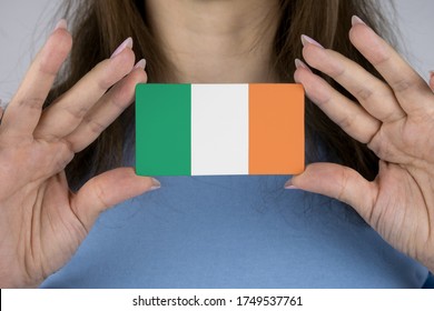 A Woman Shows A Business Card With An Image Of The Irish Flag