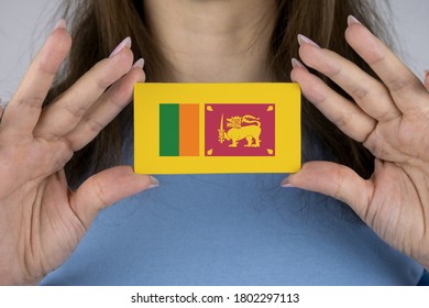 A Woman Shows A Business Card With An Image Of The Sri Lanka Flag.