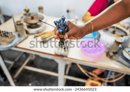 Woman shows selected blue gemstones in jewelry manufacture in mine, Sri Lanka