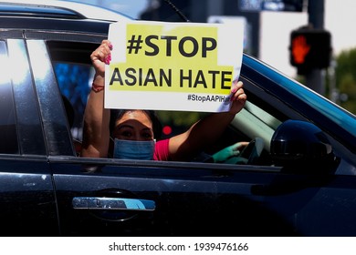 A woman shows a sign in her vehicle during a car caravan in Koreatown to protest hate crimes committed against Asian-American and Pacific Islander communities on March 19, 2021 in Los Angeles.