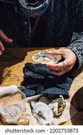 Woman Shucking And Eating Oysters At Outdoor Restaurant 