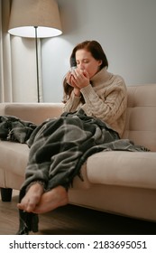 Woman Is Sick With The Flu Virus While Sitting At Home Is Treated With Hot Tea. The Concept Of The Common Cold.