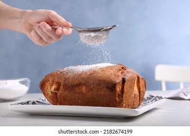 Woman sifting sugar powder onto fresh cake on light table, closeup - Powered by Shutterstock