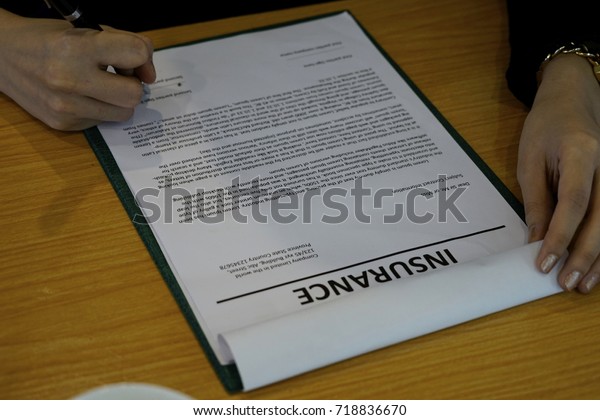 The woman sign on\
the insurance document. 