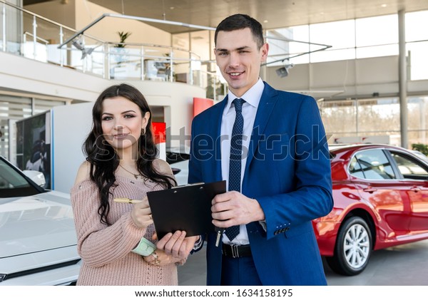 Woman signing
contract with dealer in
showroom