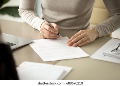 Woman signing document, focus on female hand holding pen, putting signature at official paper, subscribing name in statement with legal value, contract management, good business deal, close up view - Shutterstock ID 688690210